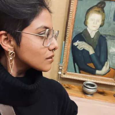 Sabeen Ahmed looking at a painting of a woman