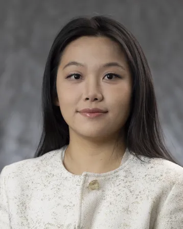 Tan wearing a white sweater and smiling
