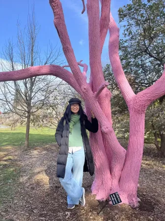 Yalin Du standing beside a tree painted pink
