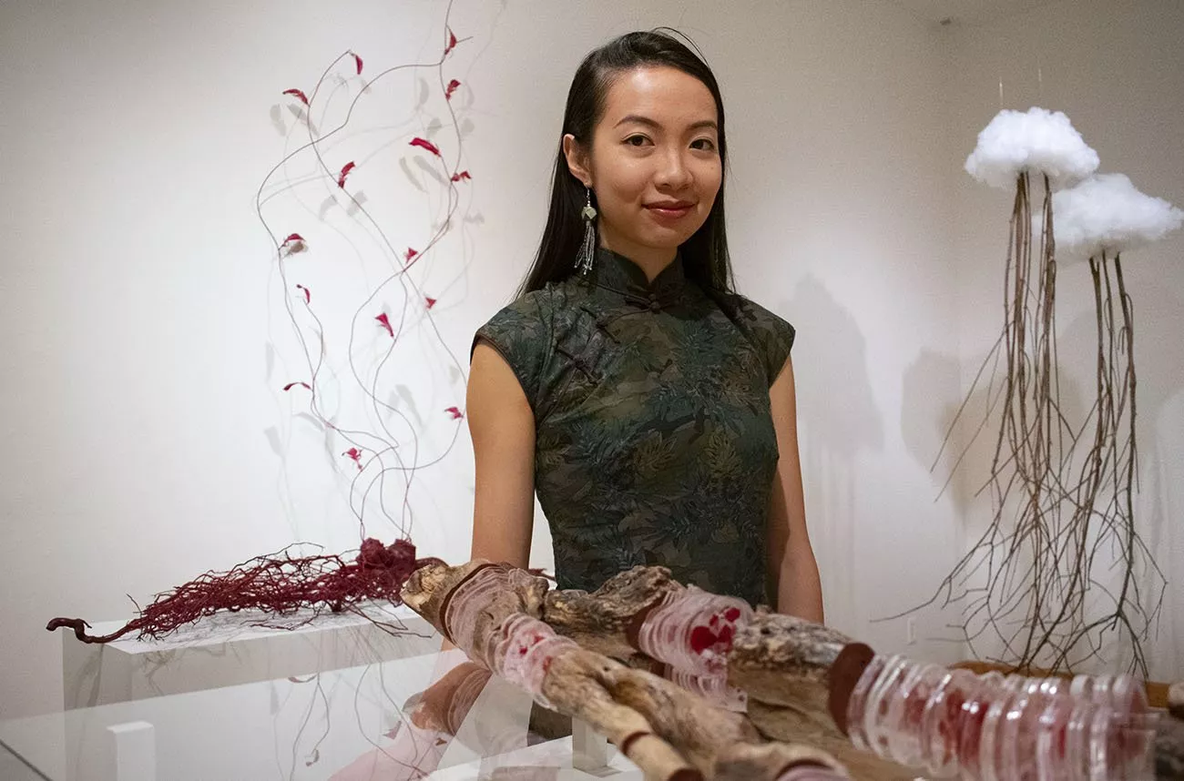 Student stands in front of sculpture in List Gallery exhibit