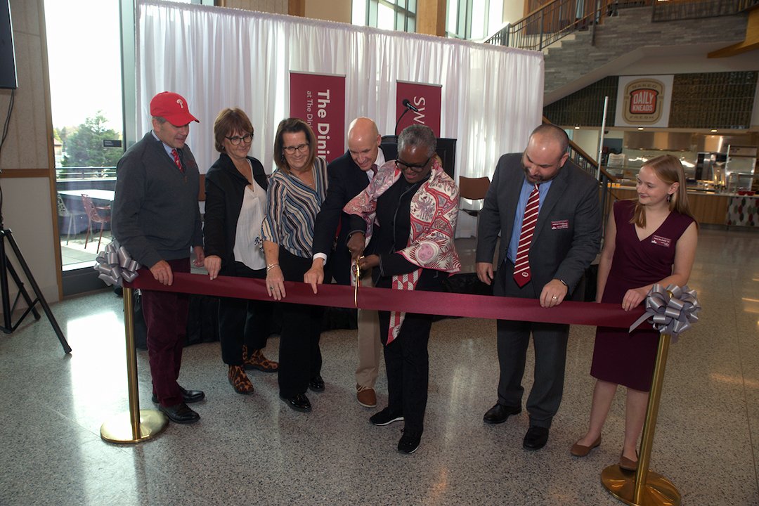 Group of people cut garnet ribbon with large scissors