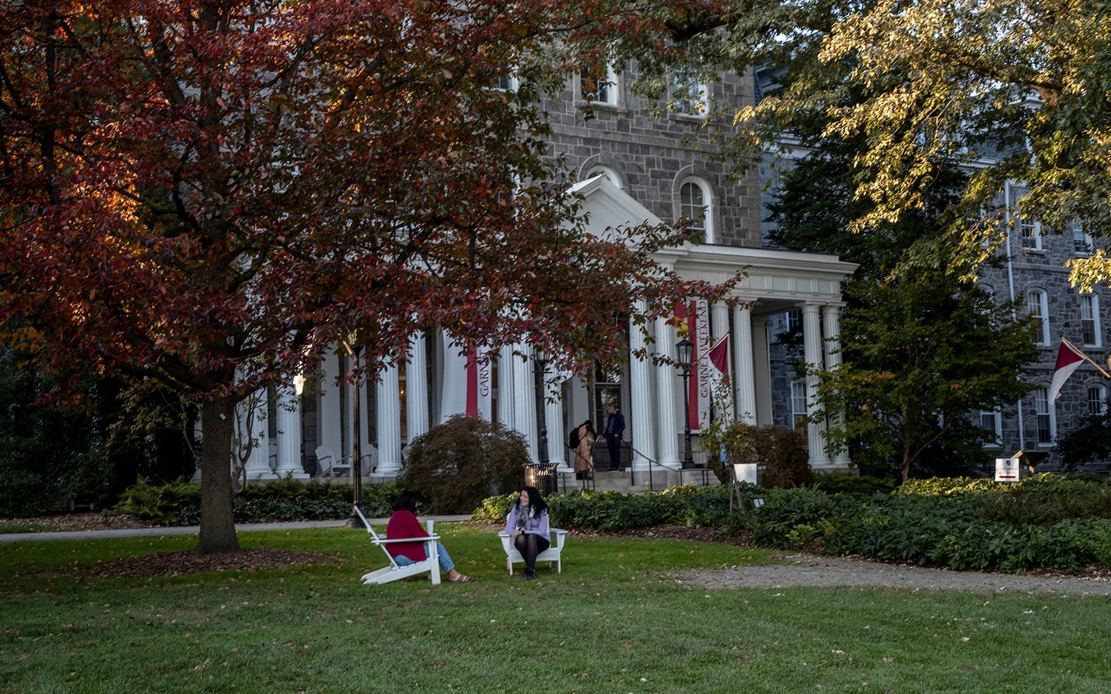 People sit on chairs in front of Parrish Hall