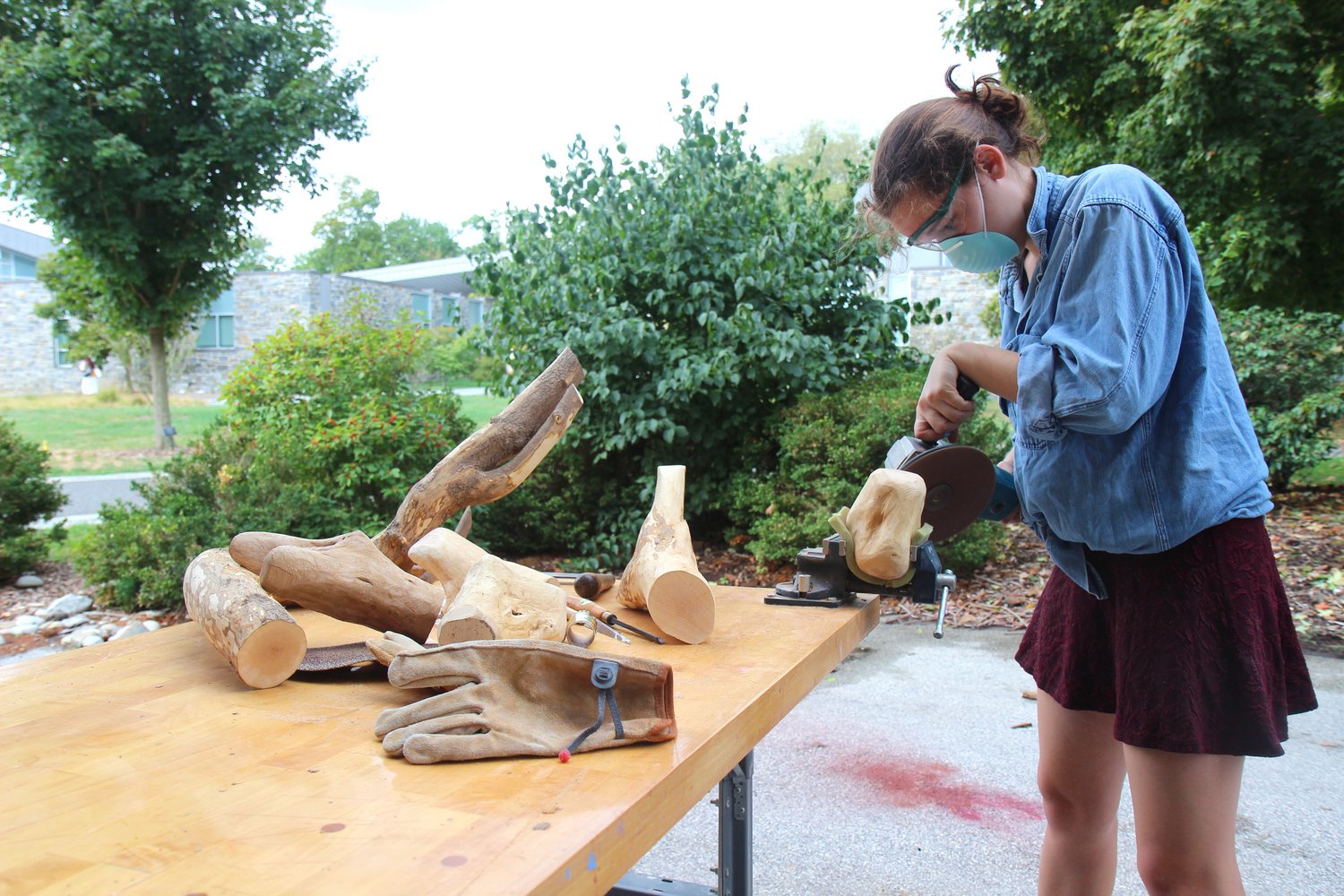 Sculpture student carving outdoors.