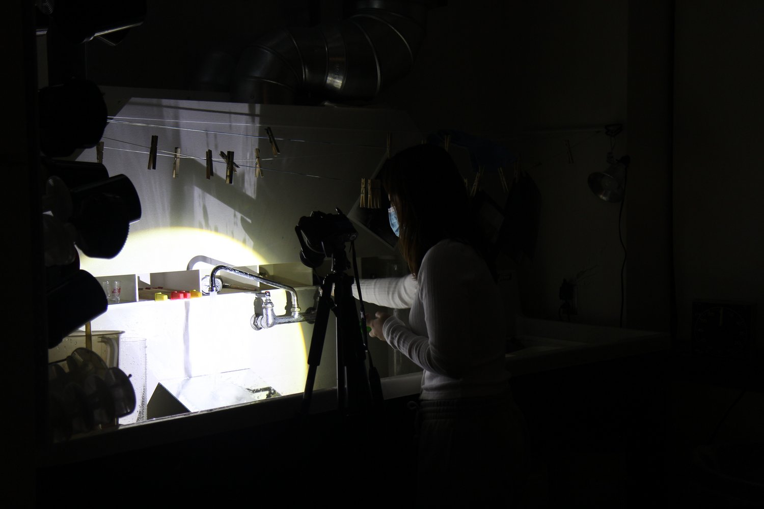 Photography Darkroom, student experimenting with developing using directed light.