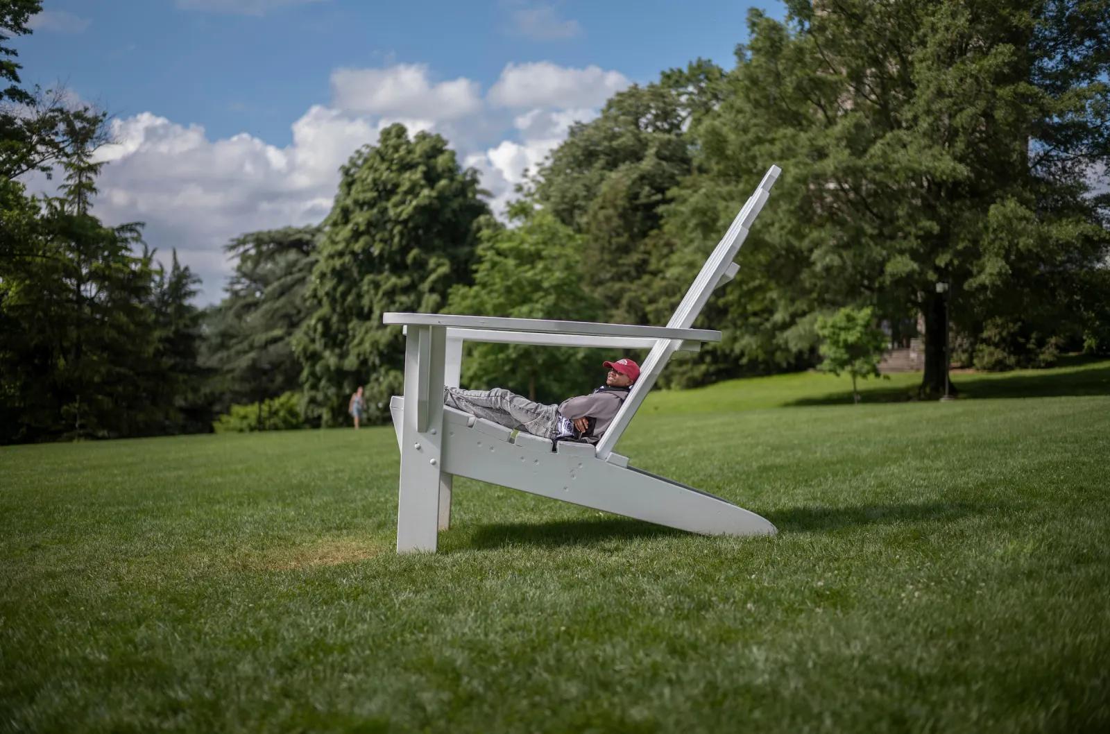 Person sits on oversized Adirondack chair