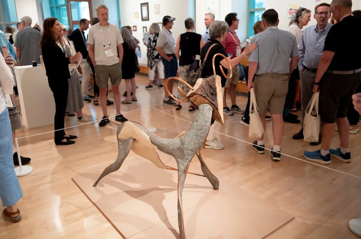 Group of alumni examine work in List Gallery