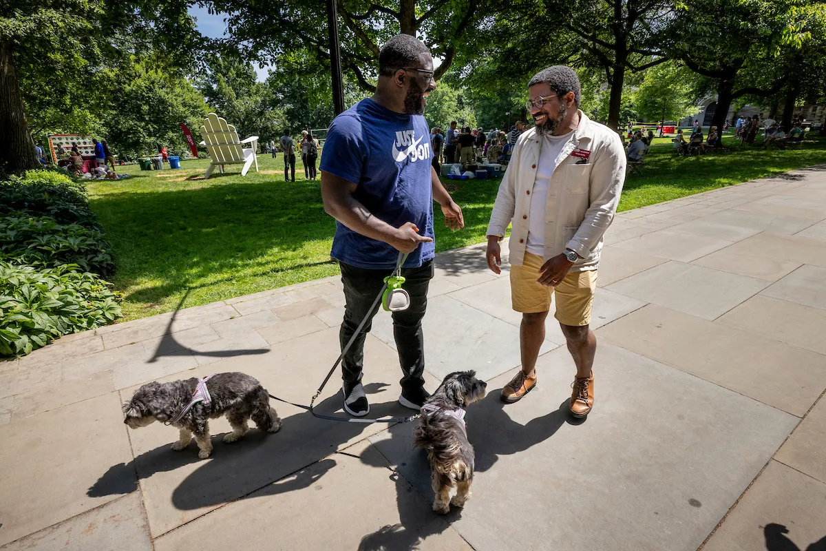 Two people walk dogs near Parrish Hall