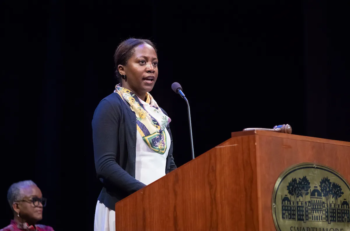 Alum speaks at podium for collection
