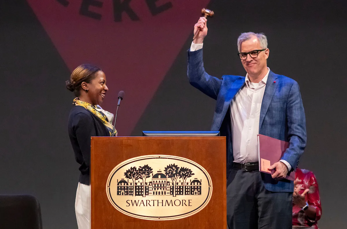 Man holds up gavel at Swarthmore podium