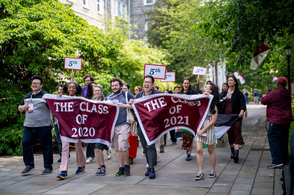 Alumni hold up banners at Parade of Classes