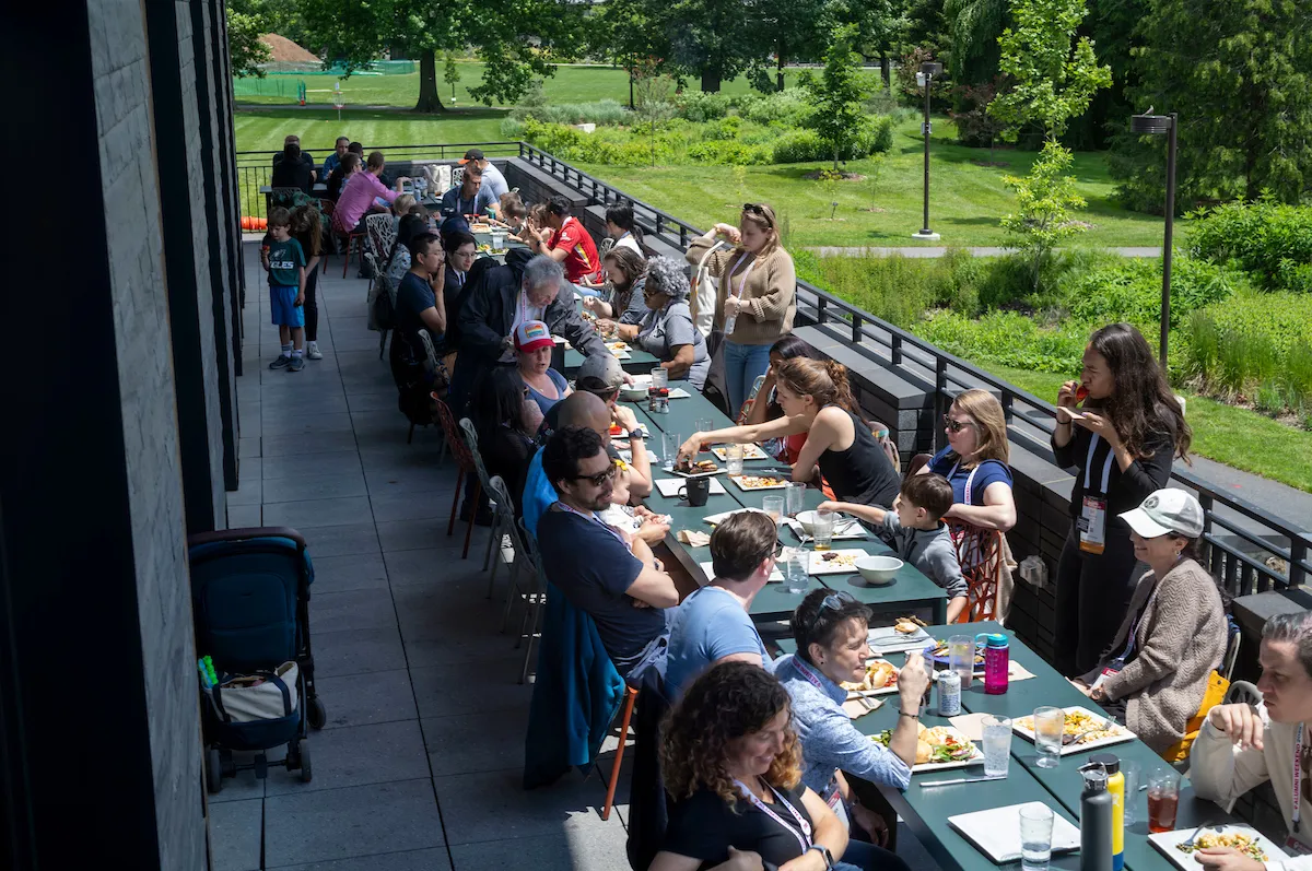 Group of alums eat outside at Dining Center