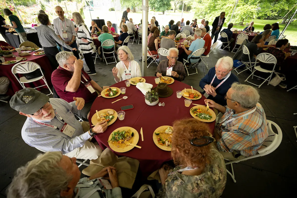 Alumni eat and sit at circular table