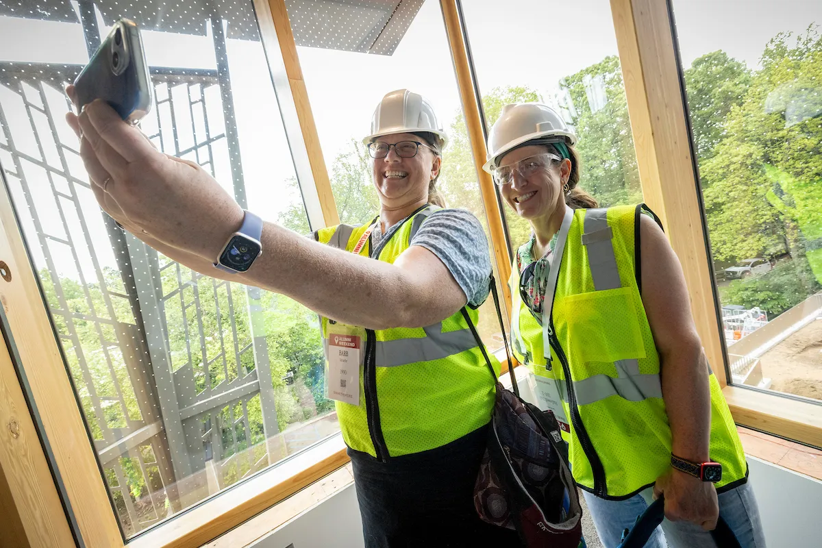 Alumni wearing hardhats take a selfie