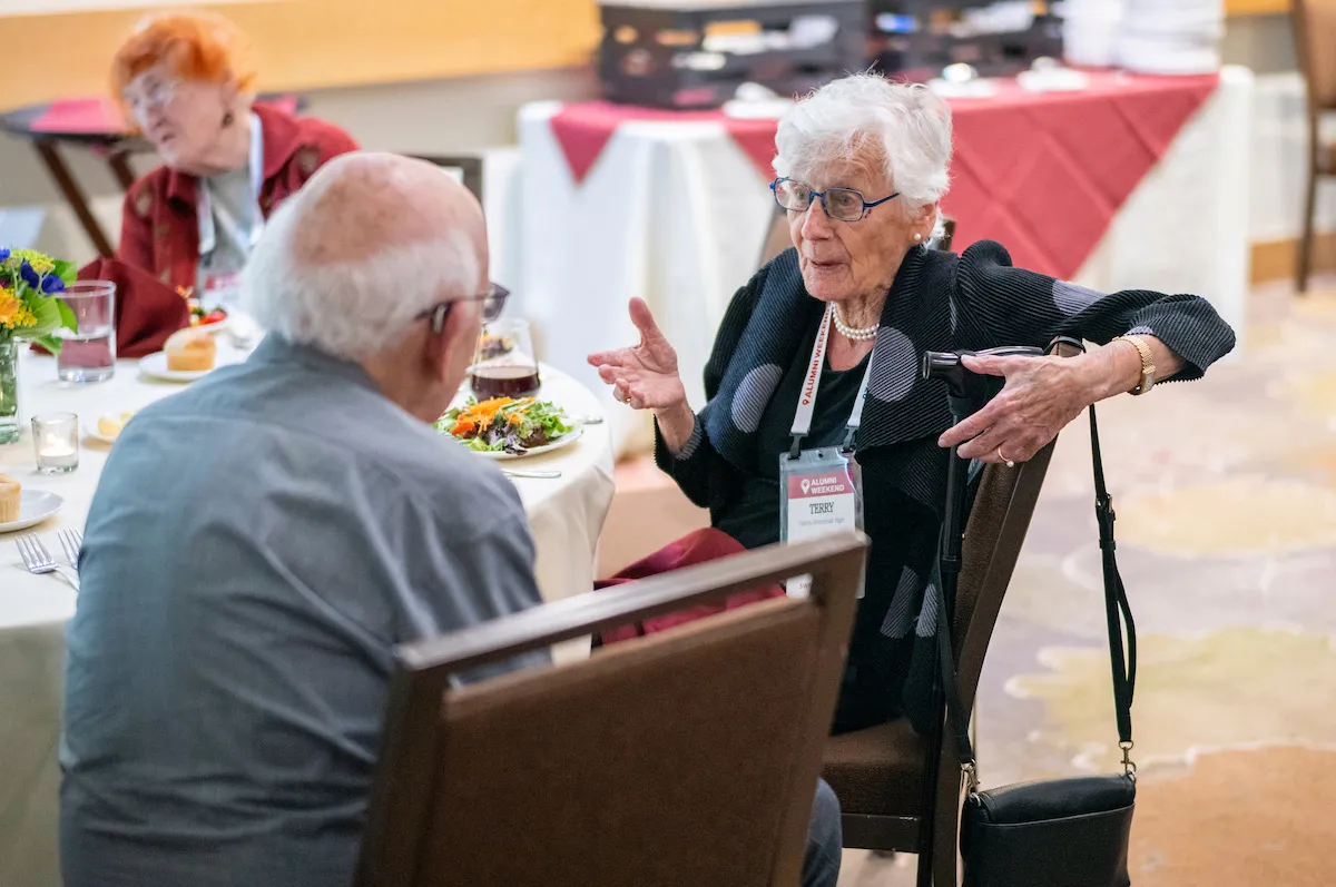 Alumni sit at table and converse