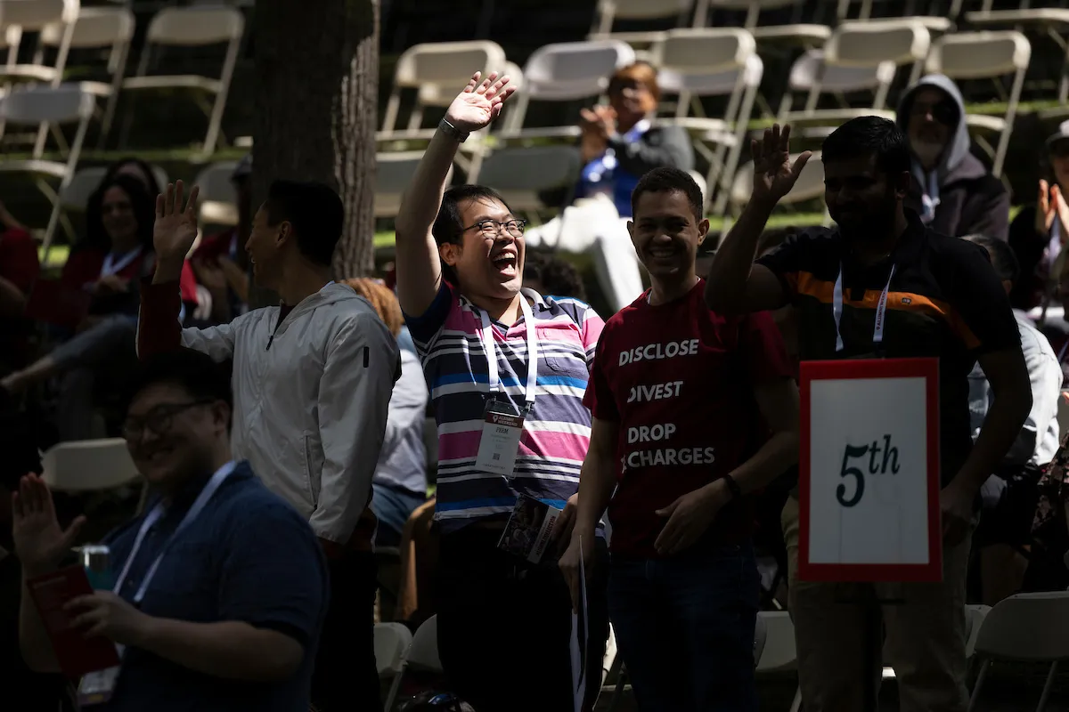 Perosn waves to crowd in outdoor amphitheater
