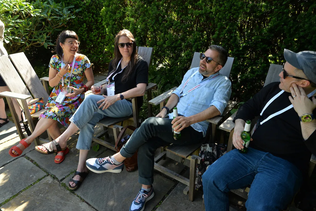 Group of alums sit on chairs outside
