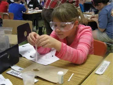 A third grade student experiments with polymers.