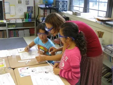 Professor Yatsunyk works with third-graders who seem fascinated by what she is doing