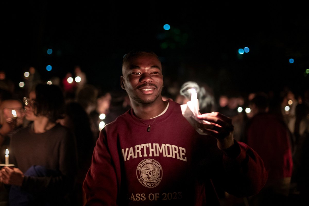 Student holds candle at night