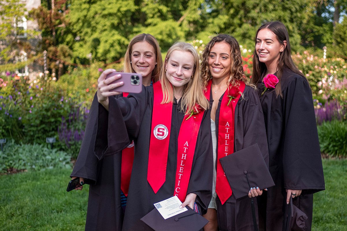 Students take a group selfie in the rose garden