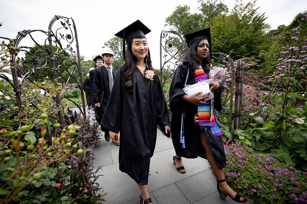 Students walk through the rose garden
