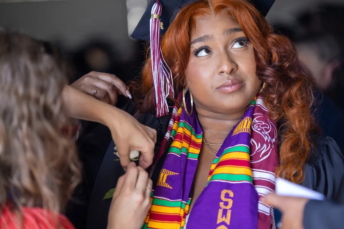Student receives rose on commencement stole