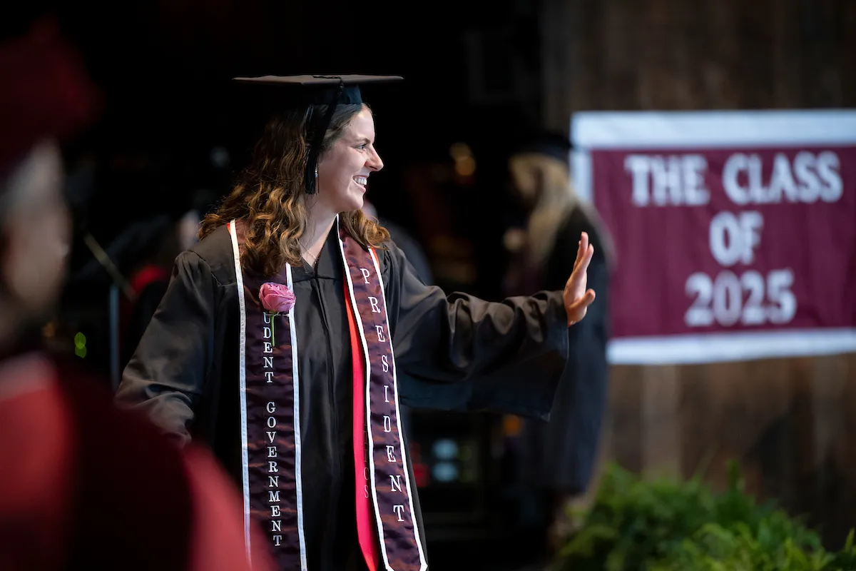 Student on stage waves to crowd