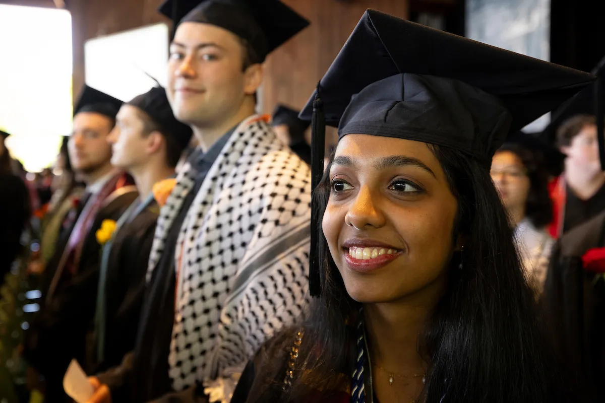 Students await walking across stage at commencement