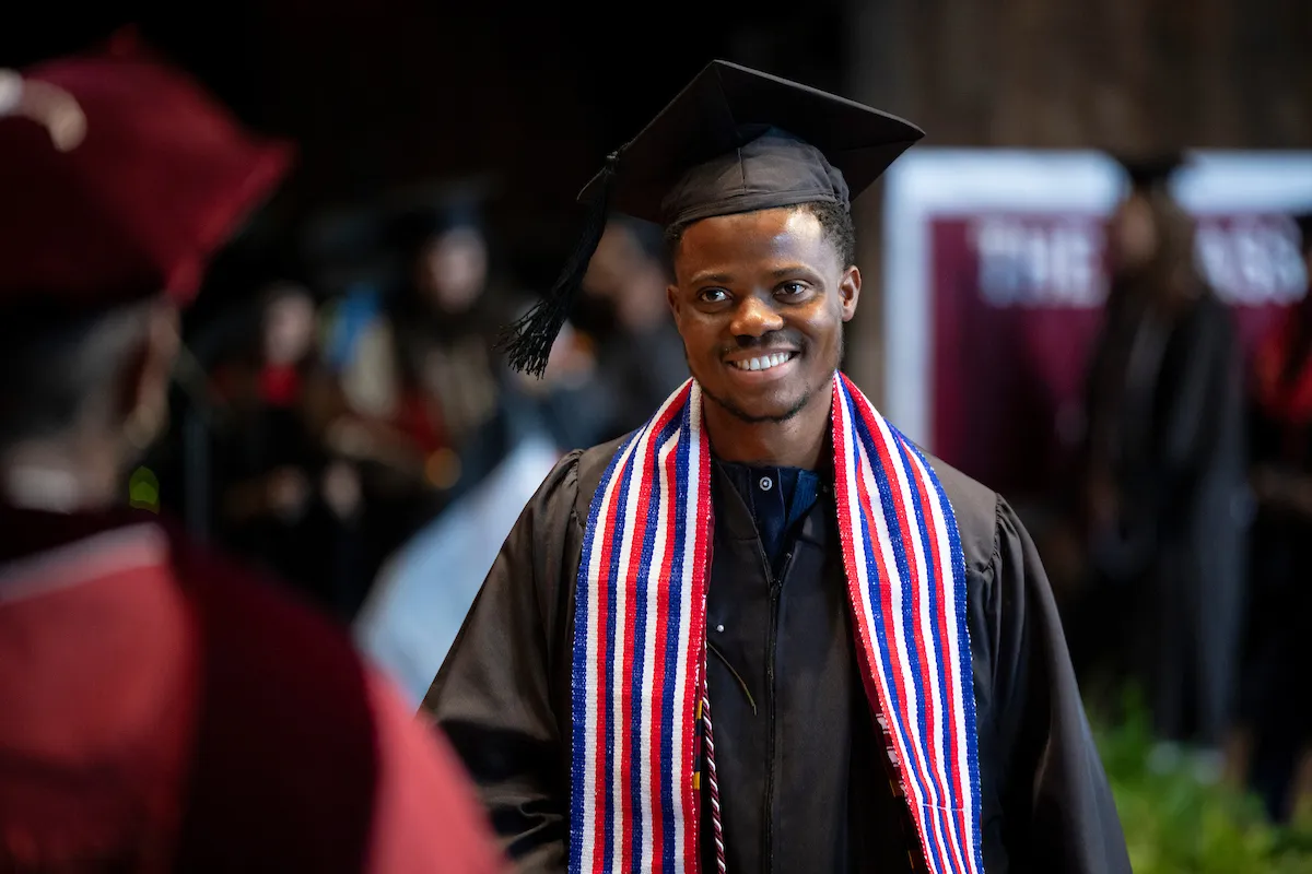 student walks across stage at commencement