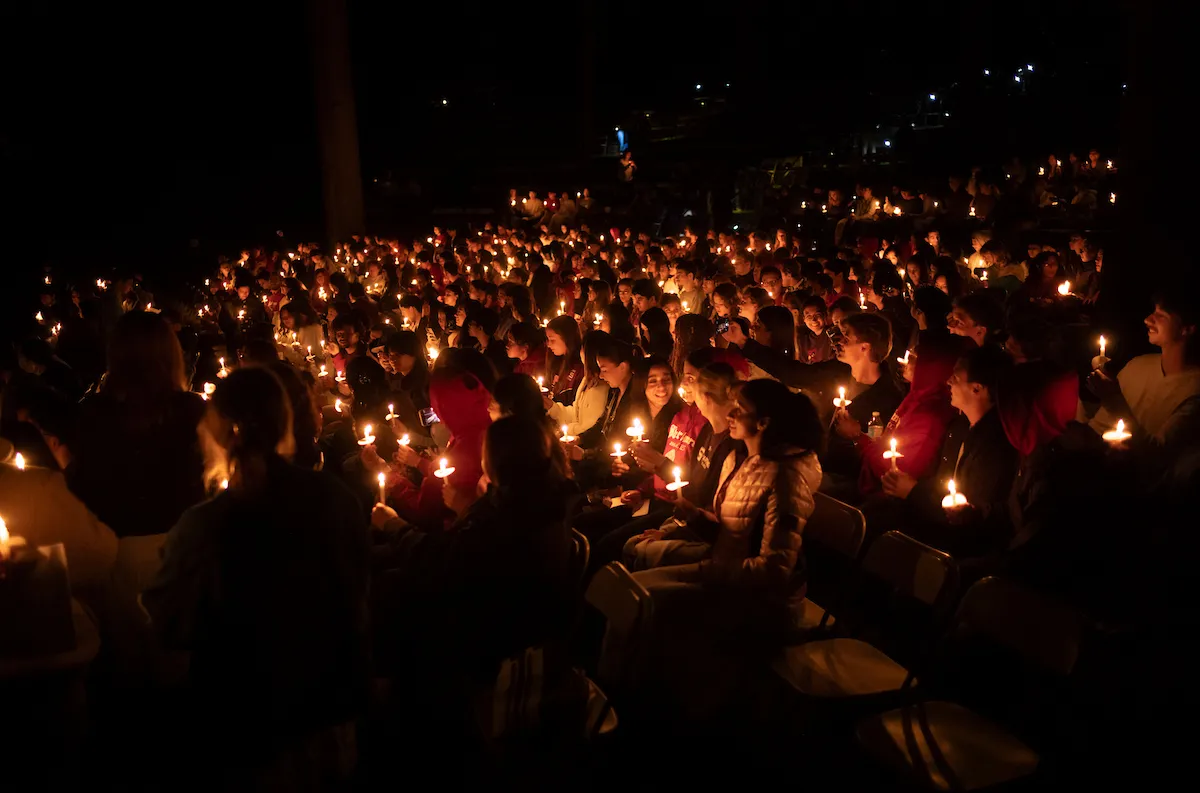 Students with candles in amphitheater at last collection