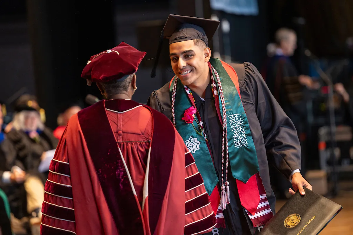 Student receives diploma from President Smith