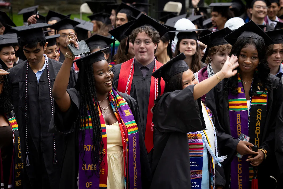 Students wave to crowd during baccalaureate
