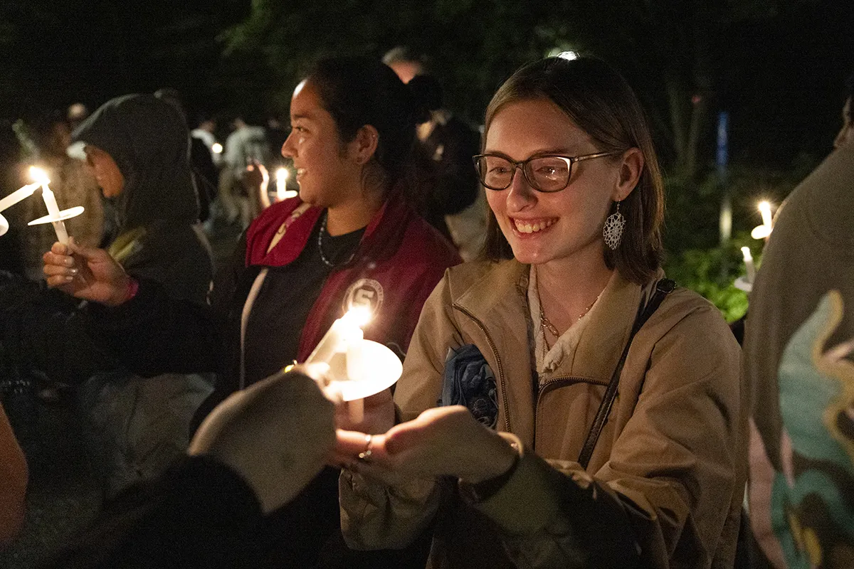Student holds candle during Last Collection ceremony