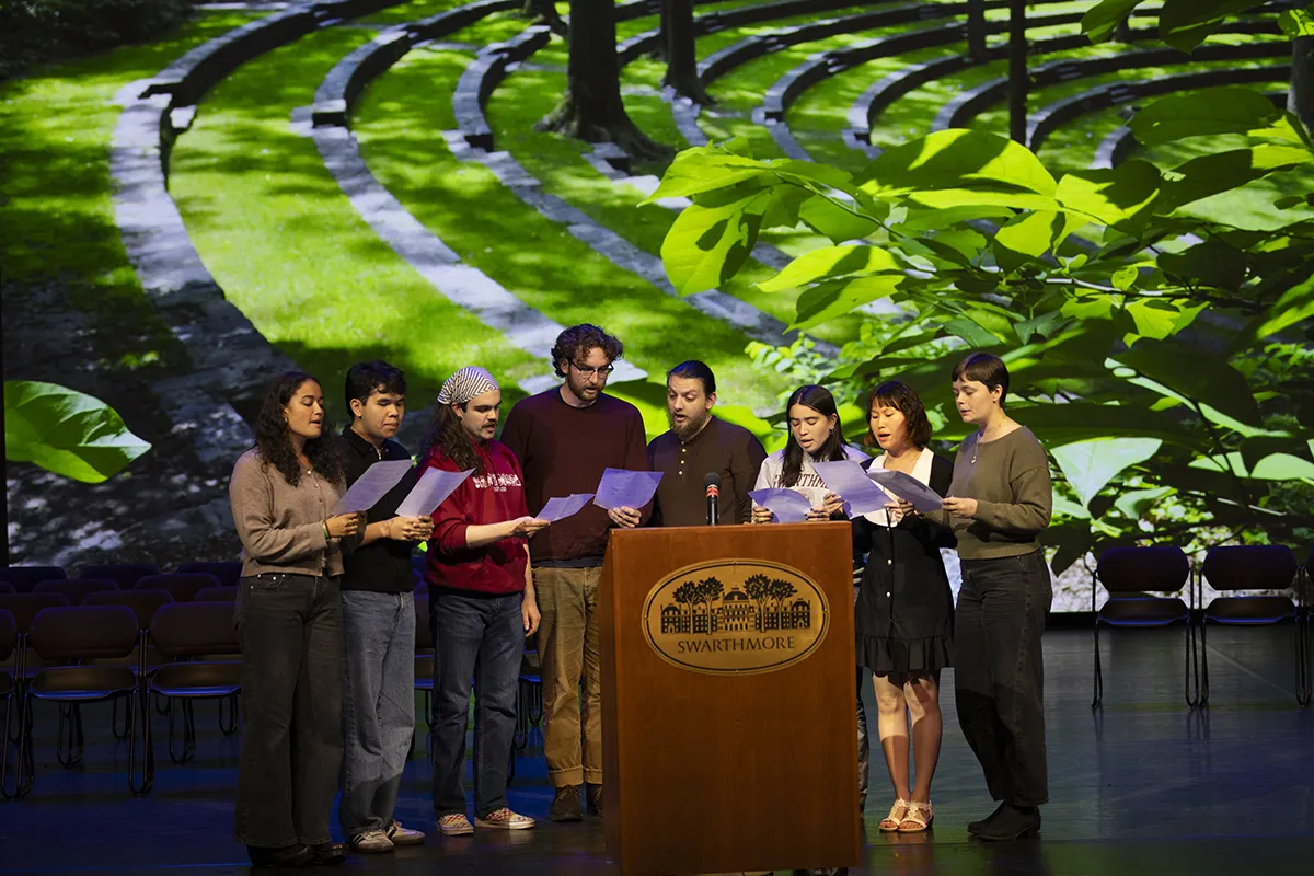 Students convened around Swarthmore podium in LPAC read alma mater from sheets of paper