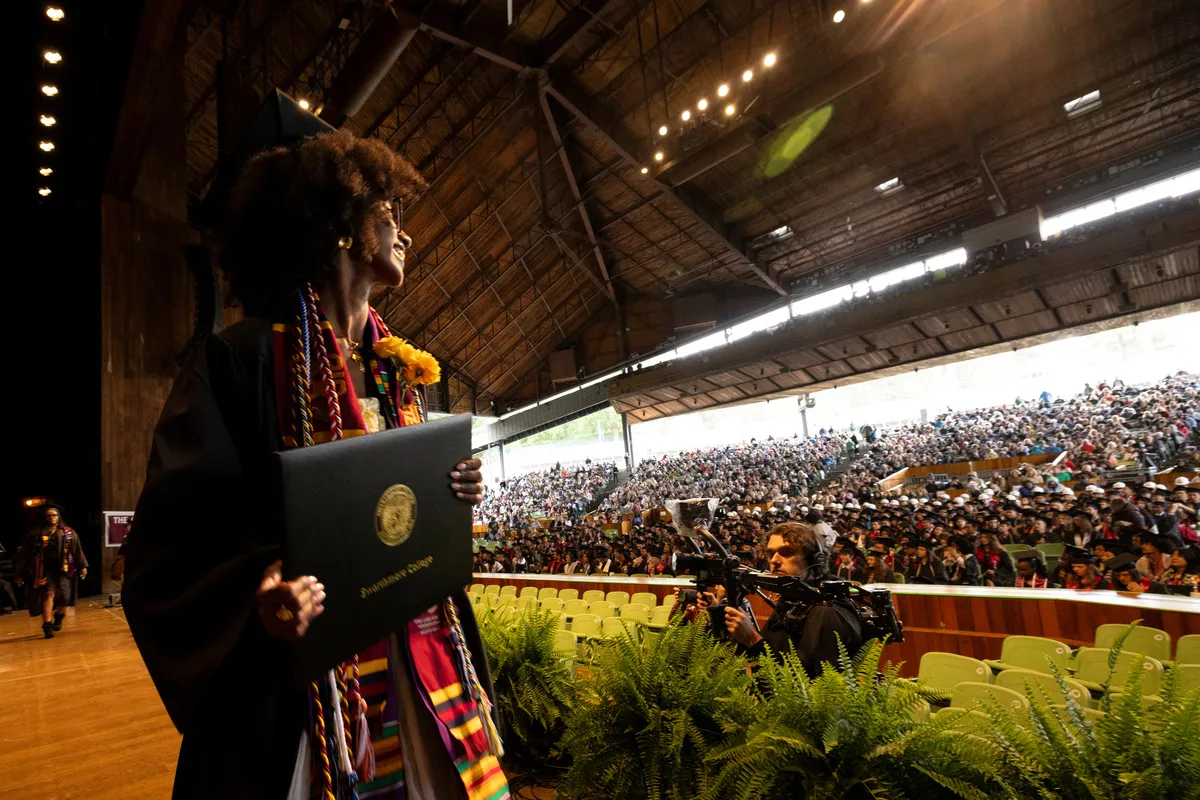 Student looks at crowd after receiving diploma