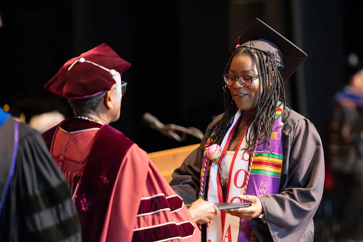 Student receives diploma from Val Smith