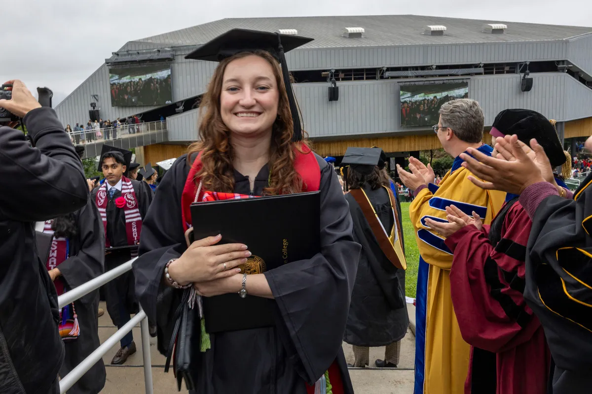 Person exits commencement with Mann Center in background