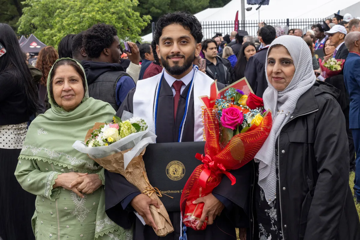 Student poses with family members after commencement