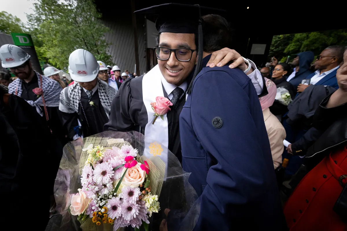 Student hugs family member after leaving commencement