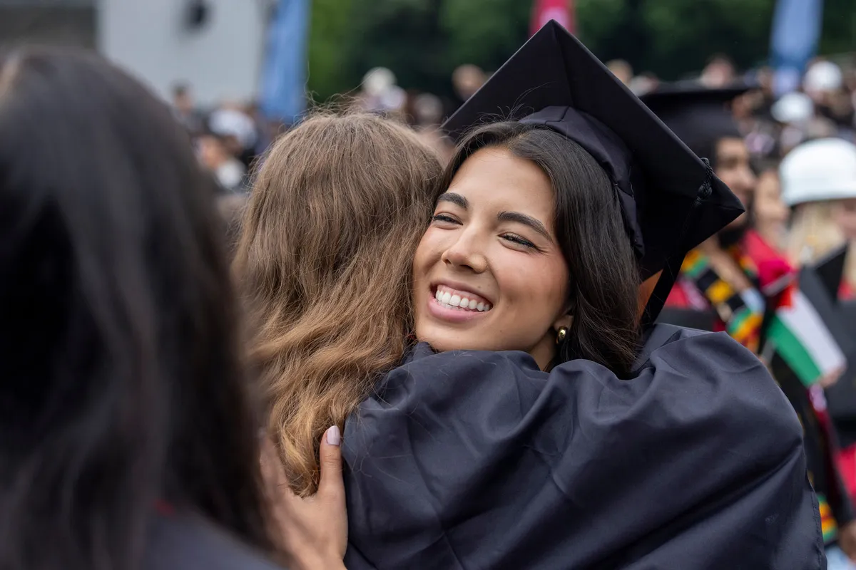 Student hugs family member after graduation
