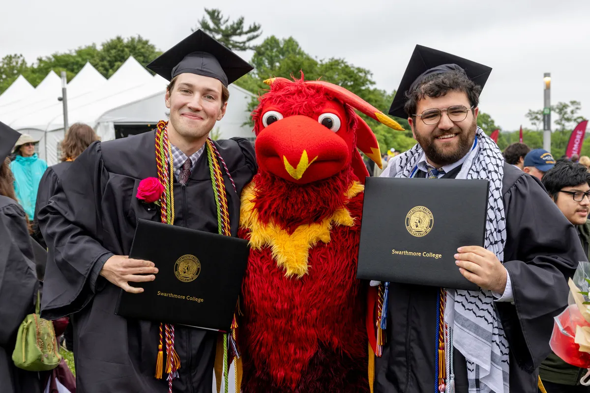 Students pose with Phineas the Phoenix after graduation