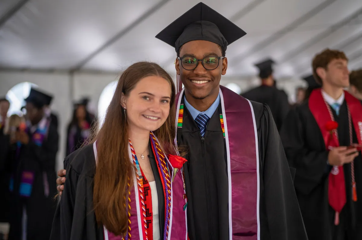 two students pose while preparing for graduation ceremony