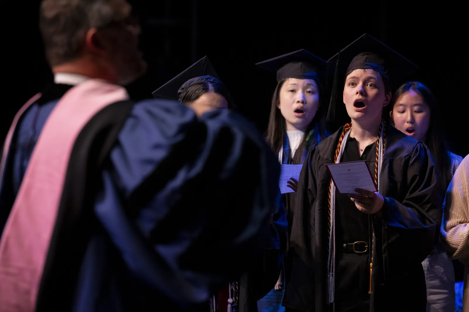 Choir performs while wearing commencement robes