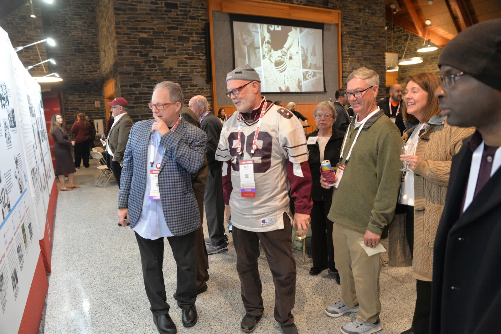 Attendees look at poster for football team history