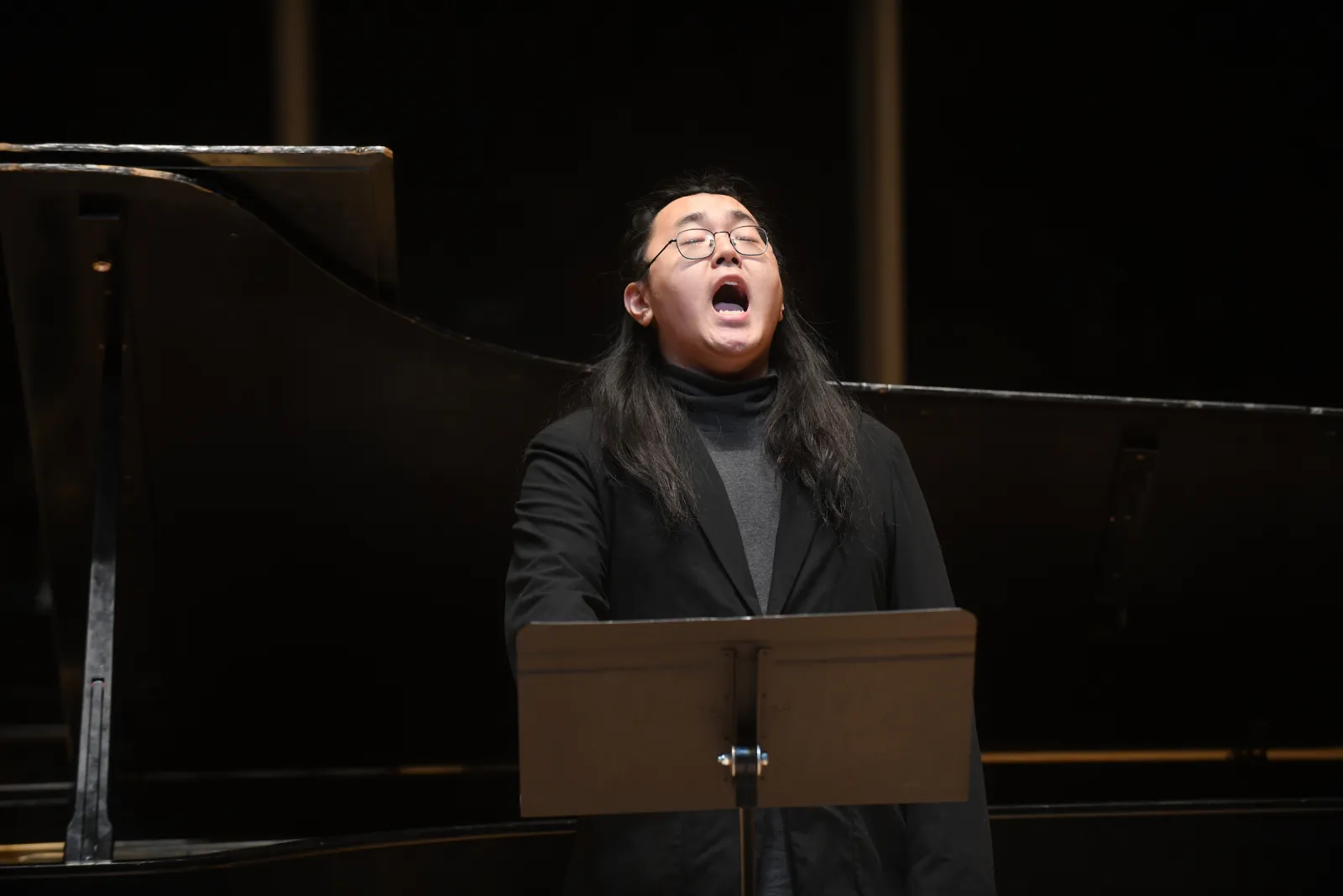 Close up of person in black shirt singing