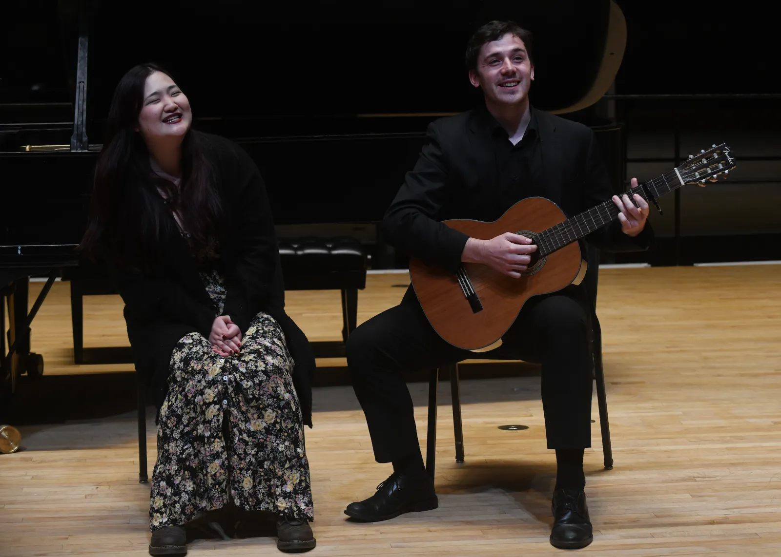 Person sings with another person sitting and playing guitar