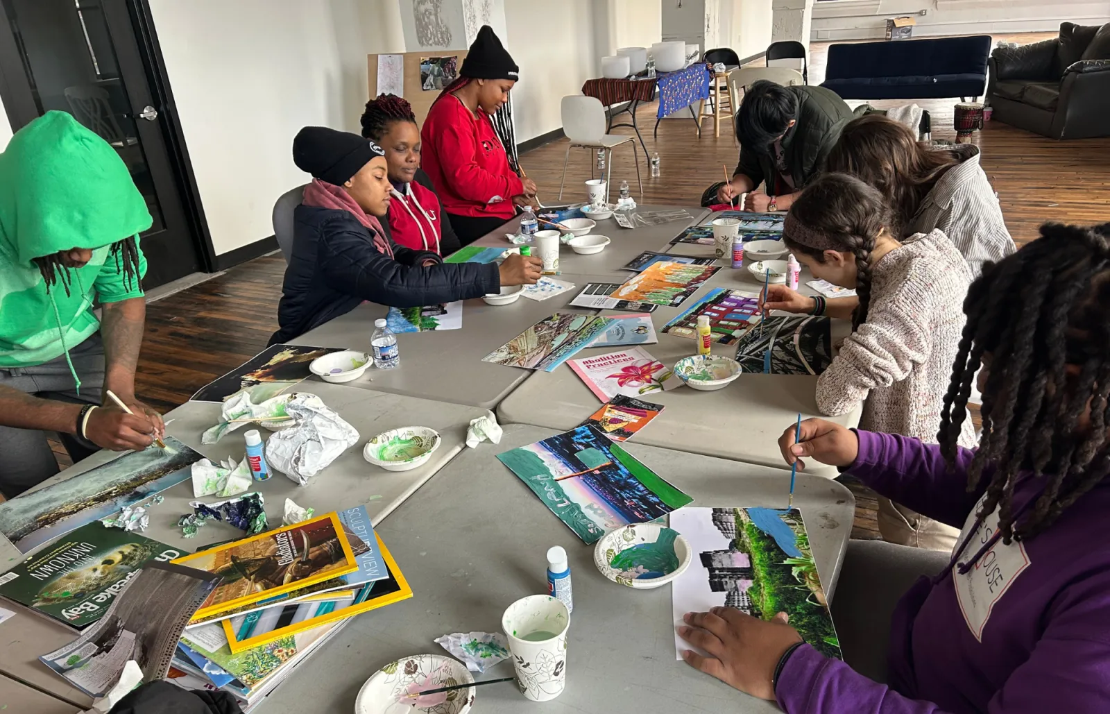 Students working on paintings around a table