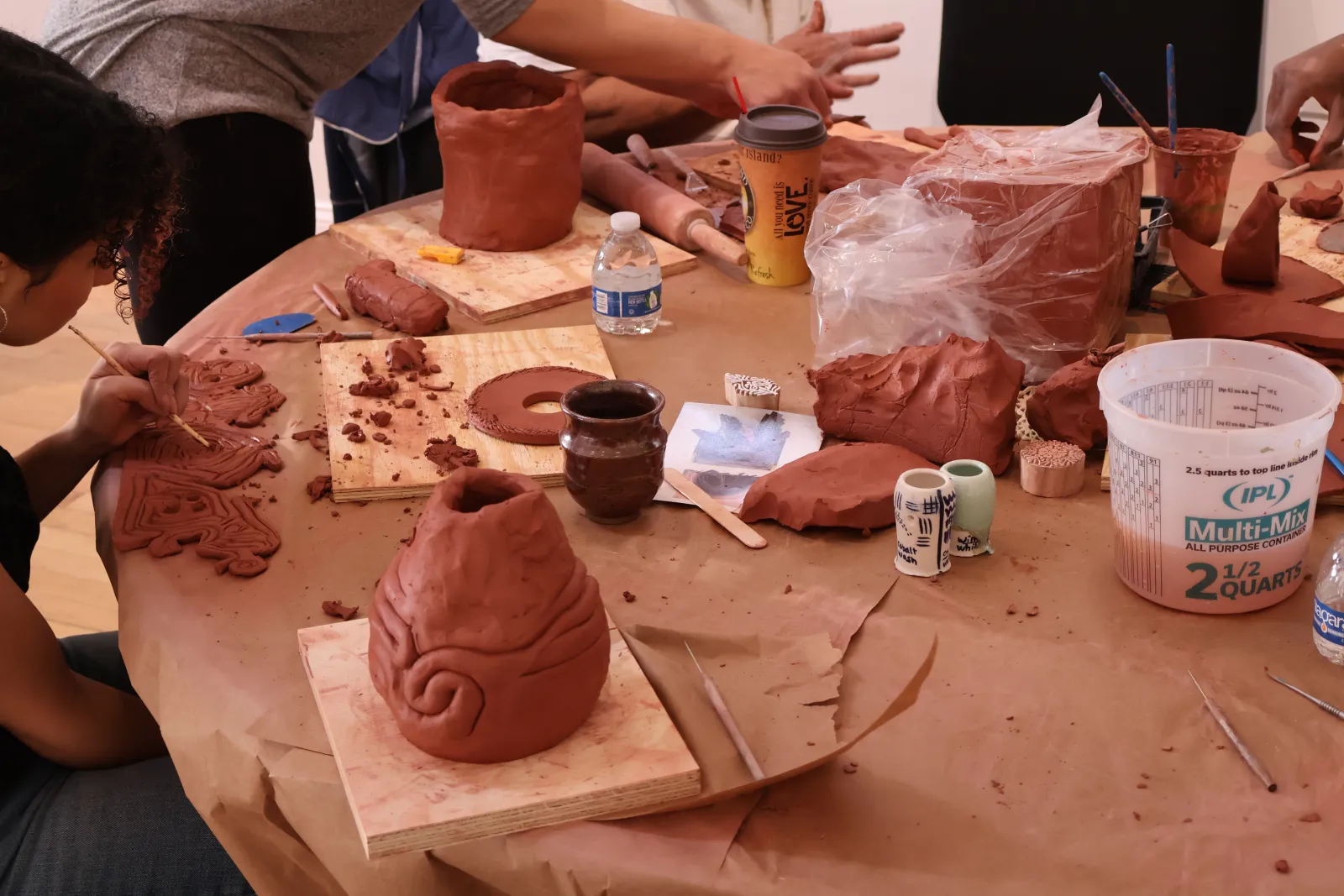 Close up of Bonding Forms participants creating clay sculptures at a table.