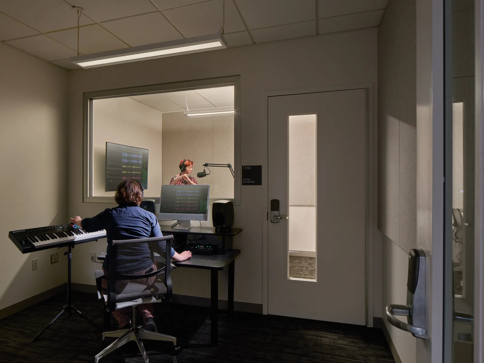 students playing musical instruments in an audio recording suite