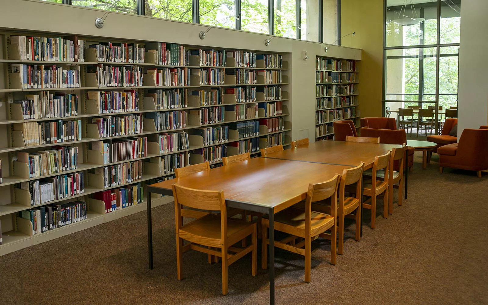 long table and chairs next to full bookshelves